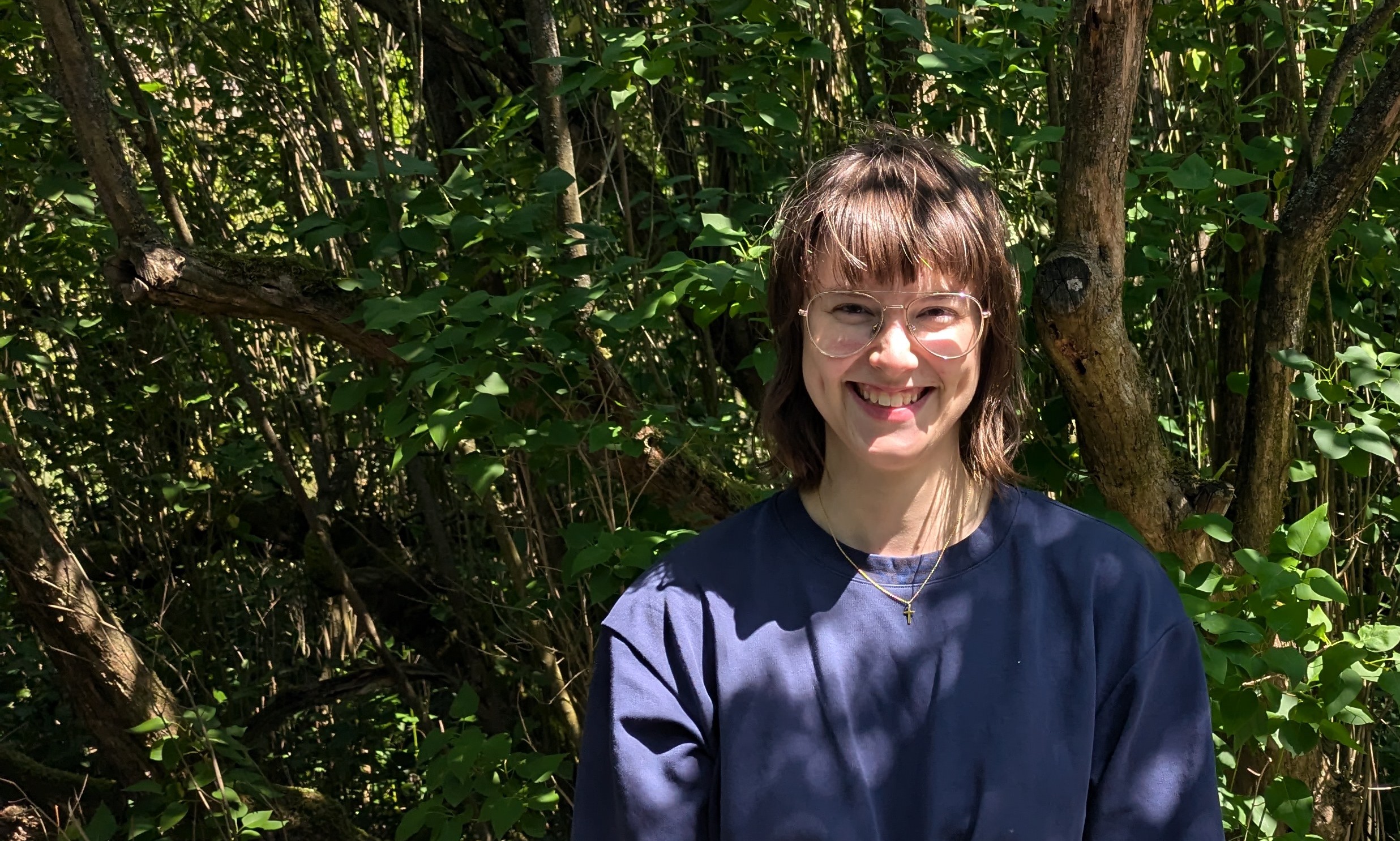 Bild einer Baksteinwand mit Blumen und einer einladenden leeren Bank davor